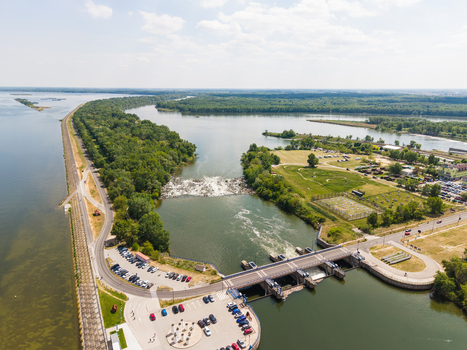 Aerial view of a river dam and water gates with parking areas and lush green forests along the Danube river in Bratislava Bratislava Region Slovakia. Aerial view of a river dam and water gates with parking areas and lush green forests along the Danube river in Bratislava Bratislava Region Slovakia.