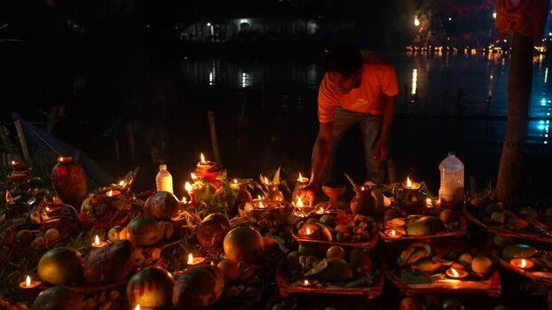 View of a man arranging oil lamps and offerings at night Bangladesh. View of a man arranging oil lamps and offerings at night Bangladesh.