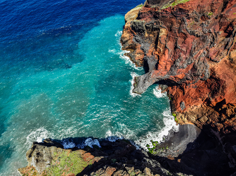 Aerial view of the dramatic contrast between the dark volcanic rock and the turquoise sea Capelo A&ccedil;ores Portugal.