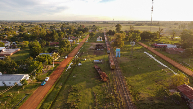 Aerial view of the rural town of Guaviravi featuring a railway line with freight cars dirt roads scattered houses and a windmill in Guaviravi Corrientes Province Argentina. Aerial view of the rural town of Guaviravi featuring a railway line with freight cars dirt roads scattered houses and a windmill in Guaviravi Corrientes Province Argentina.