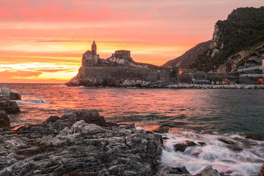 Aerial view of Chiesa di San Pietro on a rocky cliff at sunset with waves crashing against the shore Portovenere Liguria Italy. Aerial view of Chiesa di San Pietro on a rocky cliff at sunset with waves crashing against the shore Portovenere Liguria Italy.