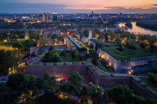 Aerial view of Belgrade Fortress surrounded by historic stone walls lush greenery and the confluence of the Sava and Danube rivers at sunset in Belgrade City of Belgrade Serbia. Aerial view of Belgrade Fortress surrounded by historic stone walls lush greenery and the confluence of the Sava and Danube rivers at sunset in Belgrade City of Belgrade Serbia.