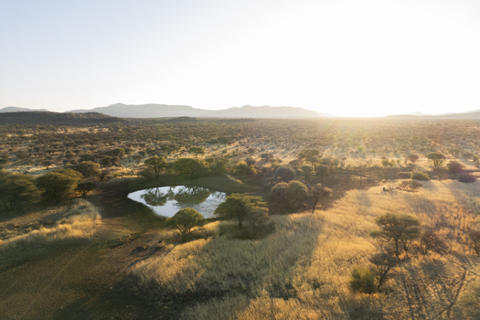 Aerial view of a small lake reflecting the sky amidst the arid landscape bathed in the warm glow of the setting sun Windhoek Namibia. Aerial view of a small lake reflecting the sky amidst the arid landscape bathed in the warm glow of the setting sun Windhoek Namibia.