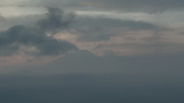 Aerial view of a mountain peak shrouded in clouds Indonesia. Aerial view of a mountain peak shrouded in clouds Indonesia.