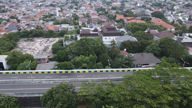 Aerial view of Jalan Pangeran Antasari showing the elevated highway surrounding residential area with trees and dense urban rooftops in Kecamatan Cilandak Daerah Khusus Ibukota Indonesia. Aerial view of Jalan Pangeran Antasari showing the elevated highway surrounding residential area with trees and dense urban rooftops in Kecamatan Cilandak Daerah Khusus Ibukota Indonesia.