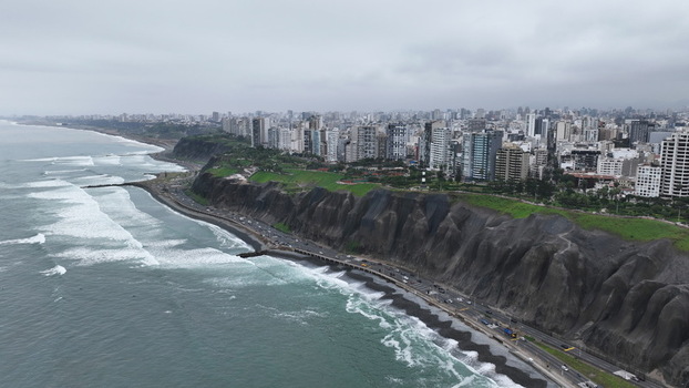 Aerial view of the Barranco district coastline in Lima featuring dramatic cliffs a coastal highway and urban buildings overlooking the Pacific Ocean in Barranco Lima Province Peru. Aerial view of the Barranco district coastline in Lima featuring dramatic cliffs a coastal highway and urban buildings overlooking the Pacific Ocean in Barranco Lima Province Peru.