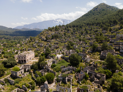 Aerial view of the historic ruins of Kayakoy Ghost Village also known as Levissi featuring stone houses and structures nestled on a hillside in Fethiye Mugla Turkiye. Aerial view of the historic ruins of Kayakoy Ghost Village also known as Levissi featuring stone houses and structures nestled on a hillside in Fethiye Mugla Turkiye.
