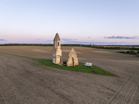 Aerial view of the historic Pusztatorony ruins surrounded by vast agricultural fields under a clear sky in Somogyvamos Hungary. Aerial view of the historic Pusztatorony ruins surrounded by vast agricultural fields under a clear sky in Somogyvamos Hungary.