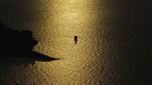 Aerial view of person walking in shallow water Brijuni Croatia.