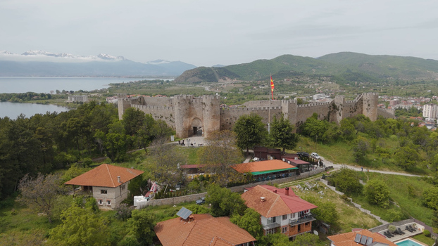 Aerial view of Samuel s Fortress overlooking Lake Ohrid with lush greenery historic stone walls and residential houses in the foreground in Ohrid Municipality of Ohrid North Macedonia. Aerial view of Samuel s Fortress overlooking Lake Ohrid with lush greenery historic stone walls and residential houses in the foreground in Ohrid Municipality of Ohrid North Macedonia.