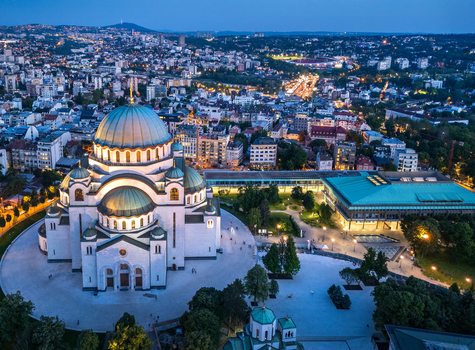 Aerial view of the illuminated Saint Sava Temple at dusk surrounded by the urban landscape and city lights of Belgrade City of Belgrade Serbia. Aerial view of the illuminated Saint Sava Temple at dusk surrounded by the urban landscape and city lights of Belgrade City of Belgrade Serbia.