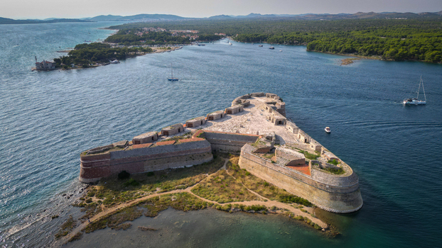 Aerial view of the triangular St. Nicholas Fortress surrounded by the blue waters of the St. Anthony Channel in Sibenik Croatia.