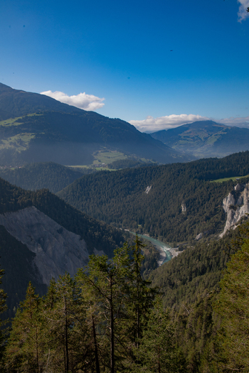 Aerial view of the Swiss Alps featuring lush green forests rocky cliffs and a winding river flowing through the valley in Airolo Ticino Switzerland. Aerial view of the Swiss Alps featuring lush green forests rocky cliffs and a winding river flowing through the valley in Airolo Ticino Switzerland.