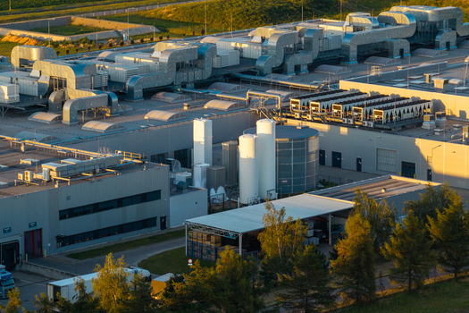 Aerial view of an advanced food production facility featuring complex ventilation systems liquid gas tanks and surrounding green landscape in mazowieckie Poland. Aerial view of an advanced food production facility featuring complex ventilation systems liquid gas tanks and surrounding green landscape in mazowieckie Poland.