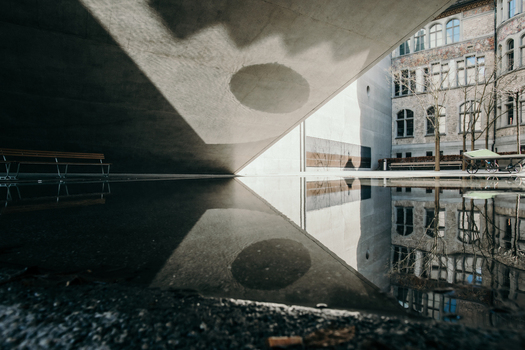View of concrete architecture reflecting in a dark pool where light and shadow dance in sharp contrast creating a surreal urban landscape Zurich Switzerland. View of concrete architecture reflecting in a dark pool where light and shadow dance in sharp contrast creating a surreal urban landscape Zurich Switzerland.