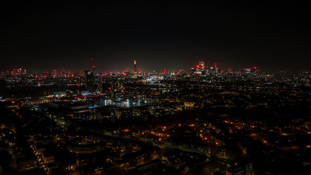 Aerial view of the London skyline at night featuring illuminated skyscrapers the Shard and city lights reflecting across the urban landscape in London England United Kingdom. Aerial view of the London skyline at night featuring illuminated skyscrapers the Shard and city lights reflecting across the urban landscape in London England United Kingdom.