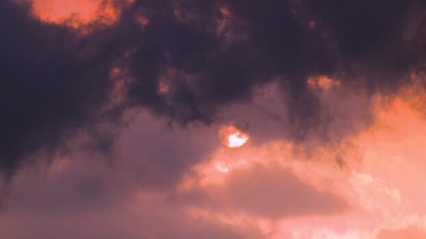 View of a crescent sun through dramatic clouds United States.