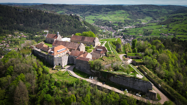 Aerial view of Fort Saint Andre with its historic stone walls overlooking the lush green Jura mountains and the valley below Salins les Bains Bourgogne Franche Comte France. Aerial view of Fort Saint Andre with its historic stone walls overlooking the lush green Jura mountains and the valley below Salins les Bains Bourgogne Franche Comte France.
