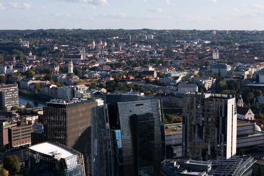Aerial view of the modern skyline and historic old town of Vilnius featuring glass skyscrapers and traditional red tiled rooftops in Vilnius Vilnius County Lithuania.