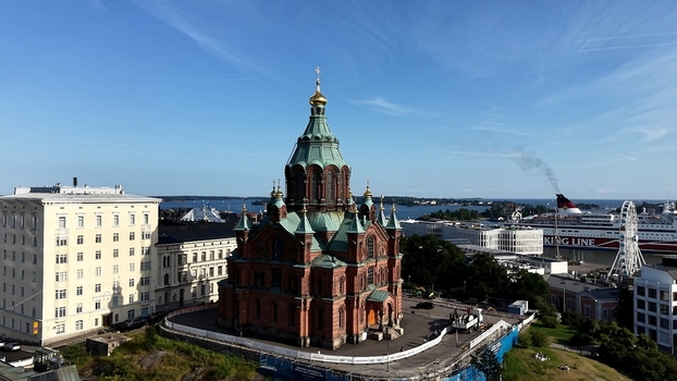 Aerial view of Uspenski Cathedral with its iconic green domes and golden crosses set against the blue sky and the harbor in Helsinki Uusimaa Finland. Aerial view of Uspenski Cathedral with its iconic green domes and golden crosses set against the blue sky and the harbor in Helsinki Uusimaa Finland.