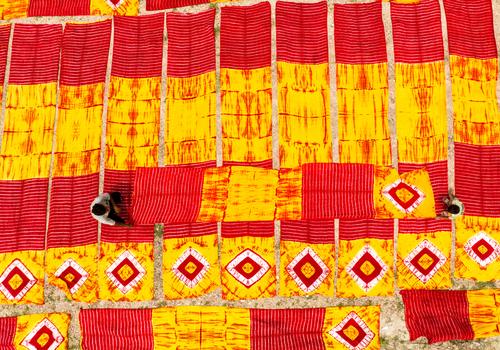 Narayanganj Bangladesh 30 March 2026 Aerial view of vibrant red and yellow fabrics laid out to dry creating a striking pattern under the bright sunlight.