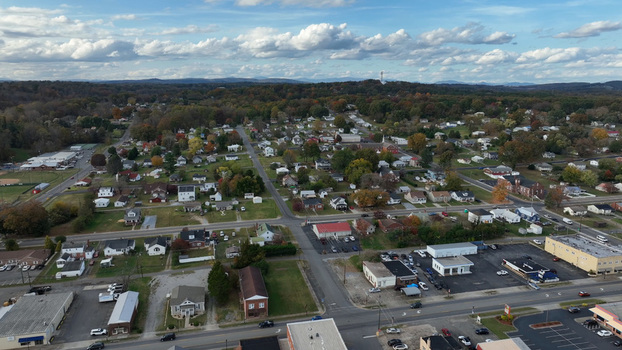 Aerial view of the town of Altavista featuring residential houses commercial buildings tree lined streets and autumn foliage under a blue sky in Altavista Virginia United States. Aerial view of the town of Altavista featuring residential houses commercial buildings tree lined streets and autumn foliage under a blue sky in Altavista Virginia United States.