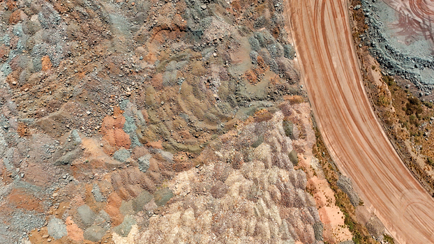 Aerial view of layered earth tones create a tapestry of textures punctuated by the stark contrast of a ruddy road slicing through the landscape Africa. Aerial view of layered earth tones create a tapestry of textures punctuated by the stark contrast of a ruddy road slicing through the landscape Africa.