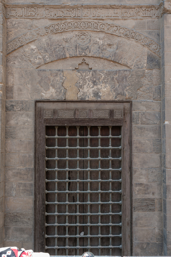 View of the historic stone facade and arched lattice doorway of the Mosque of al Salih Tala i in Cairo Egypt. View of the historic stone facade and arched lattice doorway of the Mosque of al Salih Tala i in Cairo Egypt.