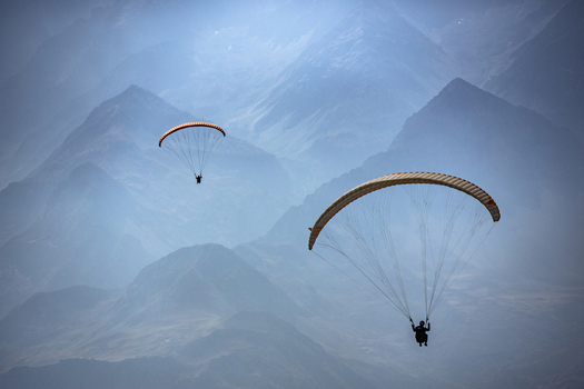 Aerial view of paragliders soaring over the rugged mountain landscape of Booni Khyber Pakhtunkhwa Pakistan.