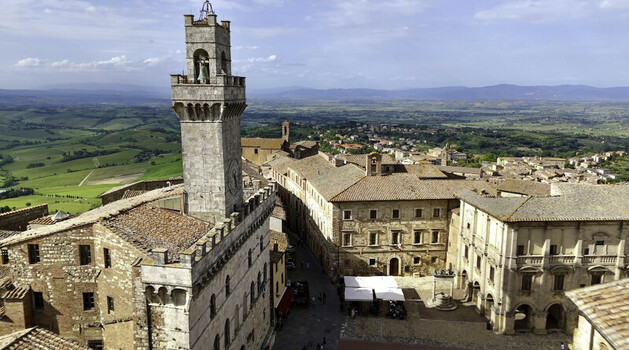 Aerial view of Piazza Grande in Montepulciano with its historic clock tower stone buildings and surrounding rolling hills of the Tuscan countryside Montepulciano Tuscany Italy. Aerial view of Piazza Grande in Montepulciano with its historic clock tower stone buildings and surrounding rolling hills of the Tuscan countryside Montepulciano Tuscany Italy.