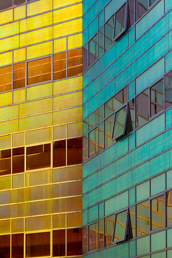 View of a modern building with a striking contrast of yellow and teal panels reflecting the sky in its windows La Defense Flevoland Netherlands. View of a modern building with a striking contrast of yellow and teal panels reflecting the sky in its windows La Defense Flevoland Netherlands.