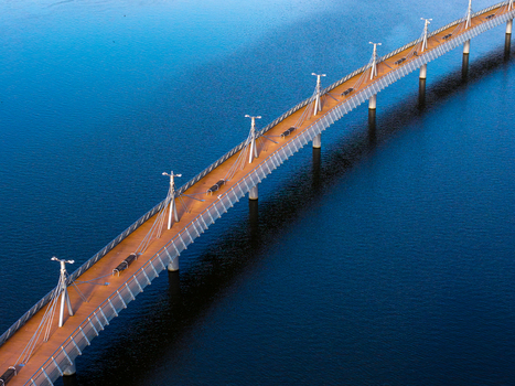 Aerial view of the Tony Halik Pier with its wooden deck and modern lighting stretching over the calm blue waters of the Vistula River in Plock Mazowieckie Poland. Aerial view of the Tony Halik Pier with its wooden deck and modern lighting stretching over the calm blue waters of the Vistula River in Plock Mazowieckie Poland.