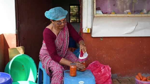 View of a woman sealing jars with an iron in Dhangadhi Nepal. View of a woman sealing jars with an iron in Dhangadhi Nepal.