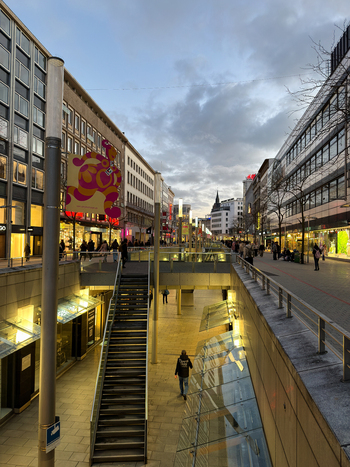 Hanover Lower Saxony Germany 30 March 2026 View of the pedestrian shopping street with modern glass staircases retail storefronts and people walking in the city center.