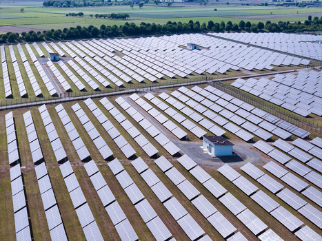 Aerial view of a large solar farm with rows of photovoltaic panels and utility buildings under bright daylight Torrazza Piemonte Piemonte Italy. Aerial view of a large solar farm with rows of photovoltaic panels and utility buildings under bright daylight Torrazza Piemonte Piemonte Italy.