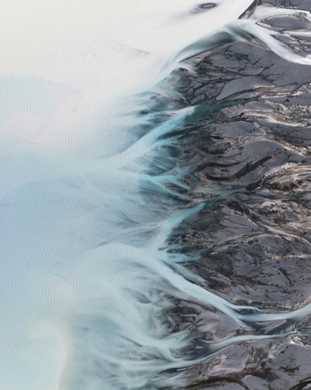 Aerial view of glacial rivers carving paths through rugged terrain contrasting icy blues with the stark rocky landscape Lake Tekapo Canterbury Region New Zealand. Aerial view of glacial rivers carving paths through rugged terrain contrasting icy blues with the stark rocky landscape Lake Tekapo Canterbury Region New Zealand.