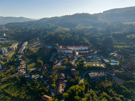 Aerial view of Pousada Mosteiro de Guimaraes on the slopes of Monte da Penha featuring historic architecture dense forests and nearby buildings Guimaraes Braga Portugal. Aerial view of Pousada Mosteiro de Guimaraes on the slopes of Monte da Penha featuring historic architecture dense forests and nearby buildings Guimaraes Braga Portugal.