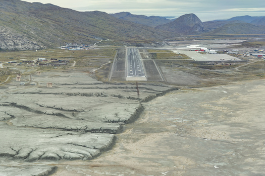 Aerial view of the stark runway cuts a path through the rugged landscape contrasting with the distant mountains Narsarsuaq Greenland. Aerial view of the stark runway cuts a path through the rugged landscape contrasting with the distant mountains Narsarsuaq Greenland.