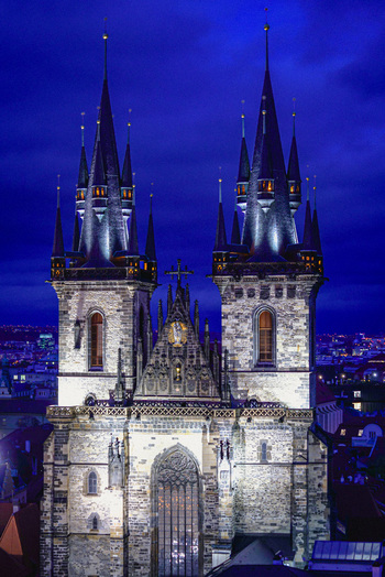 Aerial view of Church of Our Lady before Tyn with its iconic twin spires illuminated against a deep blue twilight sky in the historic city center Prague Prague Czechia. Aerial view of Church of Our Lady before Tyn with its iconic twin spires illuminated against a deep blue twilight sky in the historic city center Prague Prague Czechia.