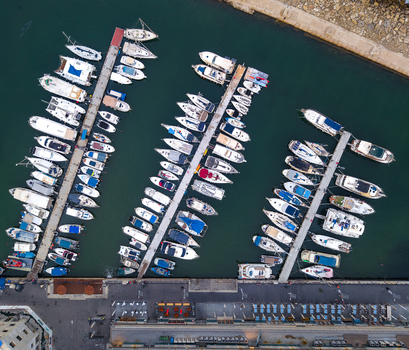 Aerial view of the Old port of Jaffa with numerous boats docked at piers in the calm turquoise water of the Mediterranean Sea in Tel Aviv Yafo Tel Aviv District Israel.