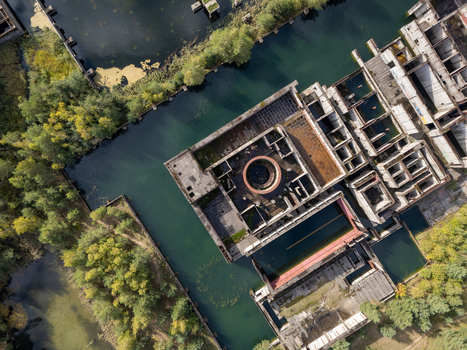 Aerial view of the abandoned concrete foundations of the unfinished Zarnowiec Nuclear Power Plant surrounded by water and dense forest in Zarnowiec Poland. Aerial view of the abandoned concrete foundations of the unfinished Zarnowiec Nuclear Power Plant surrounded by water and dense forest in Zarnowiec Poland.