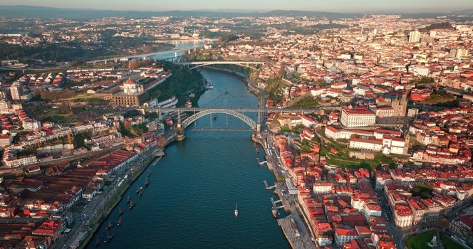 Aerial view of the Dom Luis I Bridge spanning the Douro River connecting the historic city of Porto with Vila Nova de Gaia featuring terracotta rooftops and urban architecture in Porto Porto Portugal. Aerial view of the Dom Luis I Bridge spanning the Douro River connecting the historic city of Porto with Vila Nova de Gaia featuring terracotta rooftops and urban architecture in Porto Porto Portugal.