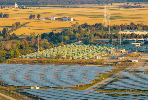 Aerial view of a large solar farm and battery energy storage facility surrounded by agricultural fields and trees in Trino Piedmont Italy.