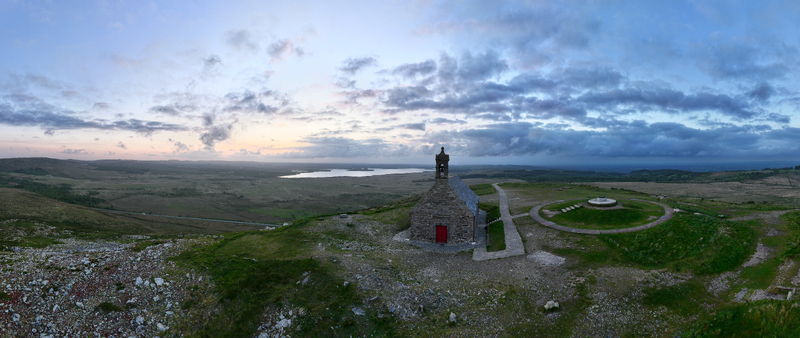 Aerial view of Chapelle Saint Michel de Brasparts on a hilltop overlooking the moorlands and Lac de Brennilis under a cloudy sky in Saint Rivoal Bretagne France. Aerial view of Chapelle Saint Michel de Brasparts on a hilltop overlooking the moorlands and Lac de Brennilis under a cloudy sky in Saint Rivoal Bretagne France.