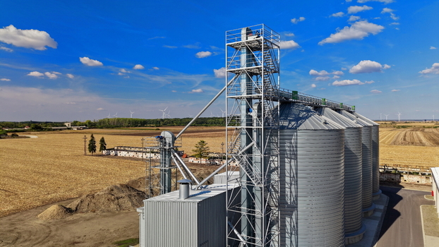 Aerial view of storage silo Bavaniste surrounded by agricultural fields and wind turbines under a clear blue sky in Bavaniste Vojvodina Serbia.