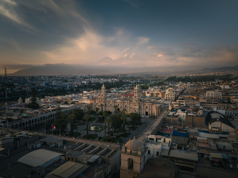 Aerial view of Plaza de Armas Arequipa with its historic cathedral palm trees and surrounding colonial architecture under a soft sunset sky in Arequipa Arequipa Peru. Aerial view of Plaza de Armas Arequipa with its historic cathedral palm trees and surrounding colonial architecture under a soft sunset sky in Arequipa Arequipa Peru.