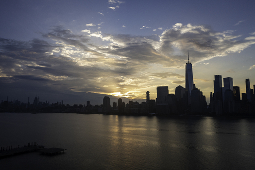 Aerial view of the New York skyline featuring One World Trade Center silhouetted against a dramatic sunset over the Hudson River in New York New York United States.