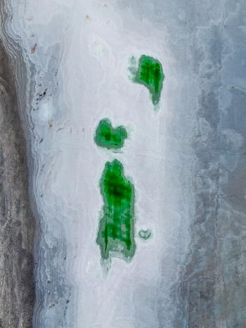 Aerial view of vibrant green phosphor deposits surrounded by white and grey salt surface in Andalusia Spain. Aerial view of vibrant green phosphor deposits surrounded by white and grey salt surface in Andalusia Spain.