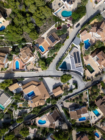 Aerial view of residential villas with swimming pools and lush gardens in Moraira Valencian Community Spain.