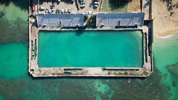 Aerial view of the stark concrete rectangle contrasts with the vibrant turquoise pool and the natural blues of the surrounding ocean Waikiki Honolulu Hawaii United States. Aerial view of the stark concrete rectangle contrasts with the vibrant turquoise pool and the natural blues of the surrounding ocean Waikiki Honolulu Hawaii United States.